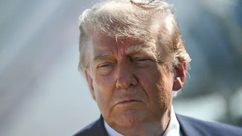 AFP via Getty Images Trump looking at camera in suit.