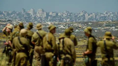 Getty Images Israeli soldiers looking at the destroyed Jabalia area, in the northern Gaza Strip, from near Kibbutz Nir Am, Israel (22 April 2026)