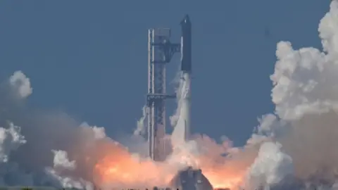 Reuters A black SpaceX Super Heavy booster carrying the Starship spacecraft lifts off.