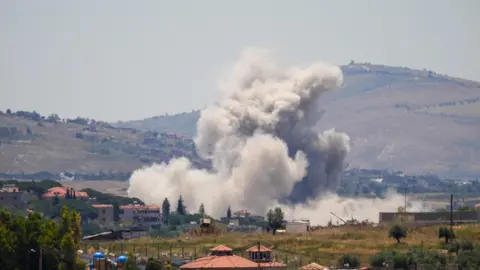 Reuters View from afar of large plumes of smoke rising over buildings struck by Israel in the Nabatieh area, southern Lebanon (4 January 2026)