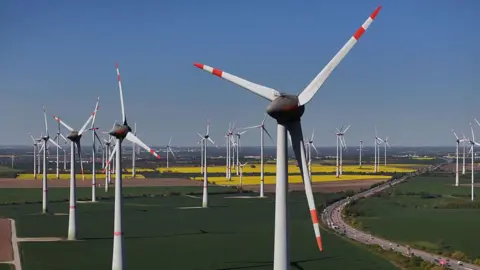 AFP via Getty Images A German wind farm, with pylons spread out across flat fields