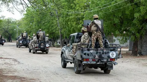 AFP via Getty Images Nigerian soldiers from the Multinational Joint Task Force (MNJTF) drive around in pick-ups during training at the MNJTF military base, Sector 3 Headquarters, in Monguno, Borno state, Nigeria, on July 5, 2025.