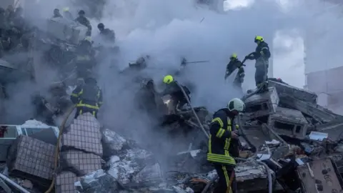 Reuters Emergency service workers search a smouldering building