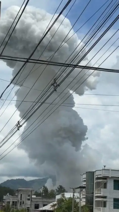 Shwe Phee Myay A huge plume of smoke rises over a village. 
