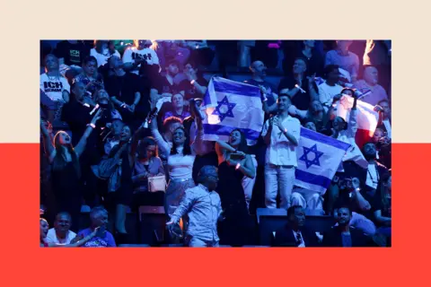 Reuters People hold Israeli flags during the second semi-final of the 2025 Eurovision Song Contest