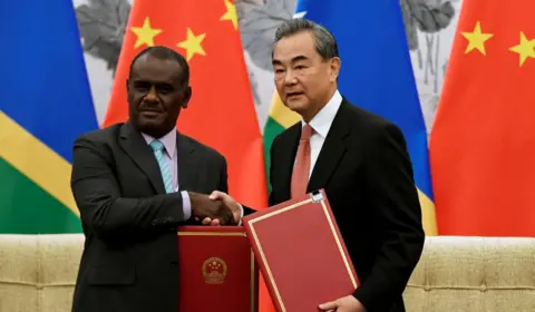 Reuters Jeremiah Manele shaking hands with China's foreign foreign minister Wang Yi in a 2019 meeting in Beijing