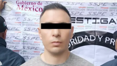 X/Omar H Garcia Harfuch The head and shoulders of a man with a black bar across his eyes