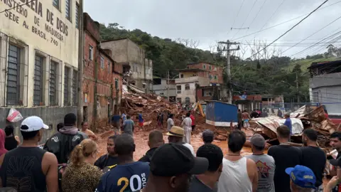 Bruno Stephan/Prefeitura de Juiz de Fora/Handout via Reuters People stand and watch as rescue workers search for missing residents
