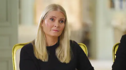 NRK A woman with blonde hair on the verge of tears in a black top