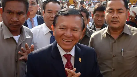 AFP via Getty Images Kem Sokha greets people in front of the Phnom Penh municipal court on April 8, 2015. 