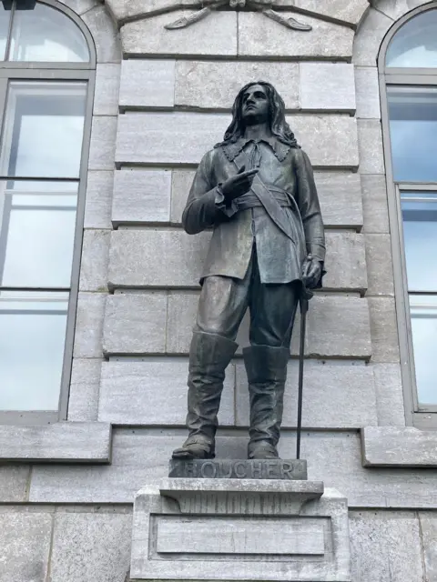 Submitted photo A bronze statue of a 17th Century aristocratic soldier holding a sword in front of a grey stone building