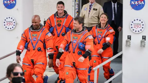 EPA Astronauts Victor Glover, Jeremy Hansen, Reid Wiseman and Christina Koch walk of a Nasa building before launch