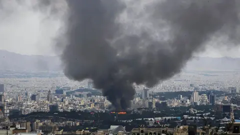 Getty Images Smoke rises from Iranian TV building as part of wide shot of city of Tehran