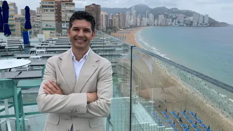 BBC Fede Fuster, tourism boss for the Spanish city of Benidorm, with the city and its main beach behind him