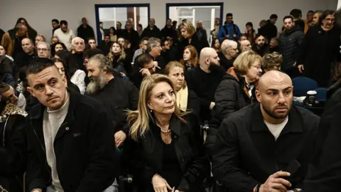 Getty Images Former Tempi 2023 Victims' Association president Maria Karystianou sits with relatives inside the 