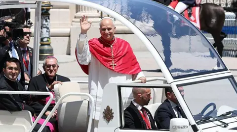 Getty Images The pope waves at crowds in Madrid from his armoured Popemobile.