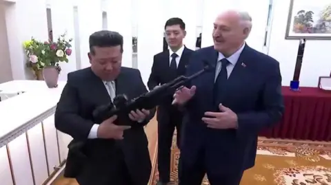 Belarus press pool North Korean leader Kim Jong Un hold a rifle given to him as a gift from Belarusian President Alexander Lukashenko