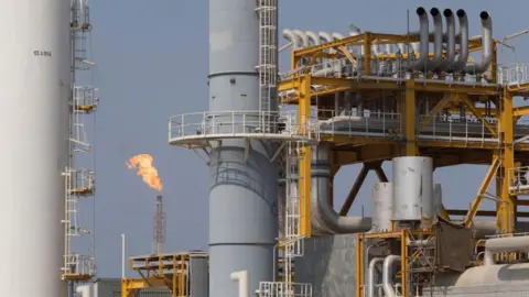 Getty Images Fire blows out of a tall chimney at a facilities on the South Pars gas field.