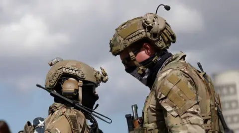 Luke Sharrett via Getty Image Two US military personnel dressed in camouflage