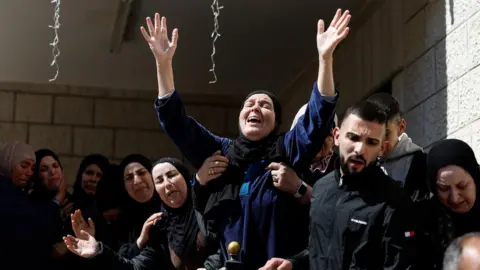 Reuters A mourner reacts during the funeral of three Palestinians killed during an attack by Israeli settlers in the village of Abu Falah, near Ramallah, in the Israeli-occupied West Bank (9 March 2026)