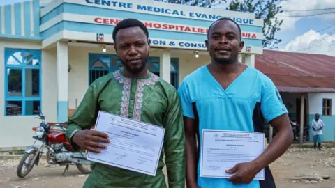 Reuters Makati Tagirabo,34, and Baraka Bulambula 29, Congolese health workers who recovered from the Ebola virus hold their certificates of discharge at the Evangelical Medical Center (CEM), as agencies intensify efforts to contain a new Ebola outbreak caused by the Bundibugyo virus strain, in Bunia, Ituri province, Democratic Republic of Congo, May 31, 2026. REUTERS/Gradel Muyisa Mumbere