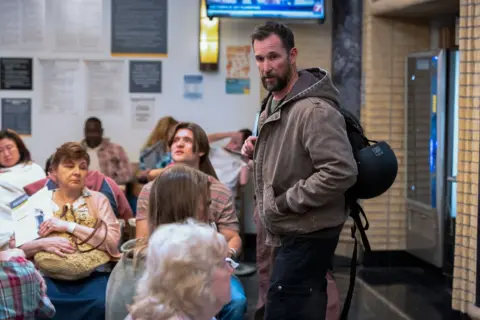 HBO Max Dr Robby (Noah Wyle) arrives in the waiting room of the hospital A&E department