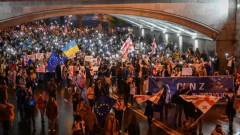 Getty Images Protesters march during a rally against the controversial "foreign influence" bill in Tbilisi 