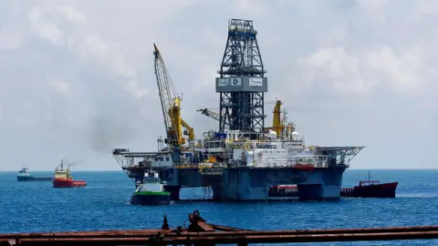 Getty Images An oil rig with ships around it.