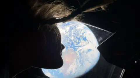 NASA Astronaut Christina Koch watching Earth from the Orion spacecraft