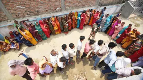 Getty Images Voters standing in a long queue for casting their votes at a polling booth during Lok Sabha election on May 20, 2024 in Saran, India. 