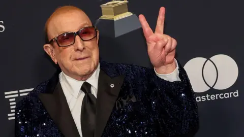 PA Media Clive Davis at the Grammys, wearing a black sequinned suit jacket.