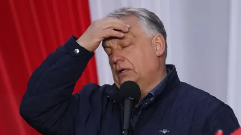 Getty Images Hungarian Prime Minister Viktor Orban rubs his forehead as he speaks at a campaign rally.