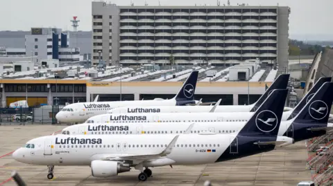 Getty Images Parked Lufthansa aircraft are lined up at Frankfurt Airport on April 13, 2026.
