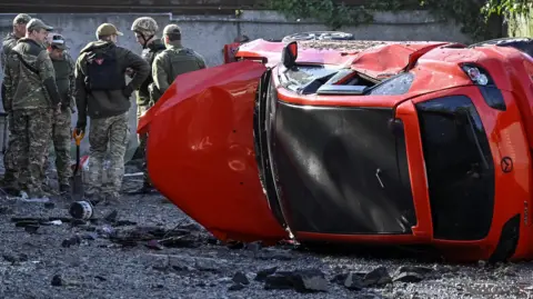 Reuters Ukrainian forces inspect a damaged car