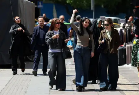 EPA A group of women walking down a street in Tehran 