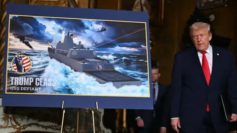 Getty Images Donald Trump next to an image of the new Trum-class battleships.
