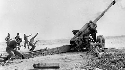 AFP via Getty Images A black and white photo of Iraqi artillery shelling the Iranian town of Abadan during the Iran-Iraq war in 1980