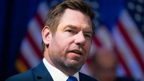 Getty Images Swalwell seen in January 2026, wearing a blue tie and a pin on his label