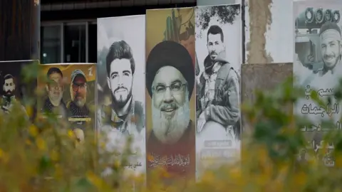 Neha Sharma/BBC A poster showing the late Hezbollah leader Hassan Nasrallah and slain fighters from the Lebanese armed group in the southern Lebanese city of Tyre