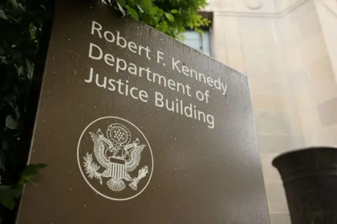 Getty Images The sign outside the DOJ is brown with an insignia. Its words say: "Robert F Kennedy Department of Justice building"
