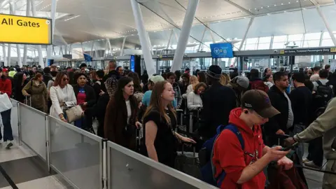 Getty Images lines lines of travellers waiting in a TSA line at the airport