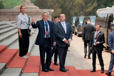 Reuters Jensen Huang, Founder, President and CEO of Nvidia gestures as he leaves after attending a welcome ceremony for U.S. President Donald Trump with Chinese President Xi Jinping at the Great Hall of the People in Beijing, China, May 14, 2026. 