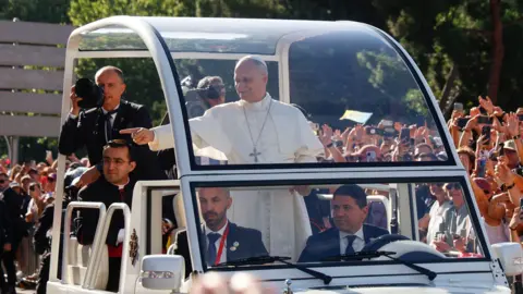 EPA/Shutterstock Pope Leo XIV waves to faithful from his popemobile as arrives to Cibeles Square to celebrate mass