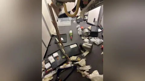 Reuters Interior of plane with food trays, water bottles and kettles strewn across the floor