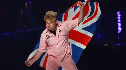 EPA Look Mum No Computer waves a British flag as he walks onto the stage at the 2026 Eurovision Song Contest