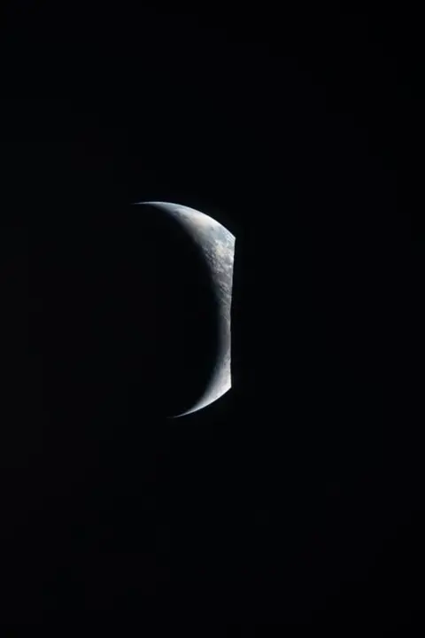 NASA Earth peaking out from behind the Moon