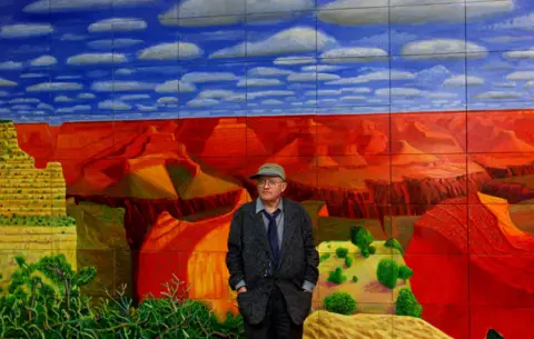 Reuters Hockney in front of one of his paintings, A Closer Grand Canyon, 1998