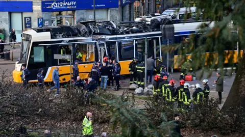 Reuters Emergency workers stand near damaged tram at scene of crash