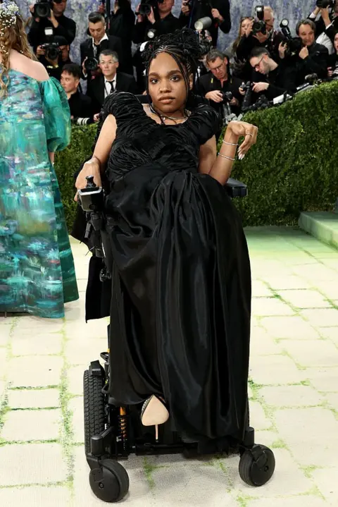 Getty Images Philip wears a black dress. She is the first wheelchair user to attend the Met Gala, according to Vogue magazine.