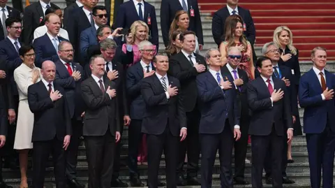 Getty Images Members of the U.S. delegation and CEOs from various industries stand prior to a welcome ceremony for U.S. President Donald Trump outside the Great Hall of the People on May 14, 2026 in Beijing, China.